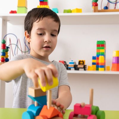 Shot of a child with wooden toy. The child collects a sorter. Educational logic toys for kids.Games for Child